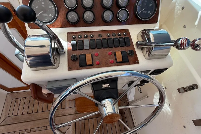 Slide: The Image of Steering wheel and controls of a 1999 Sabre 36 Express boat cockpit. - 9