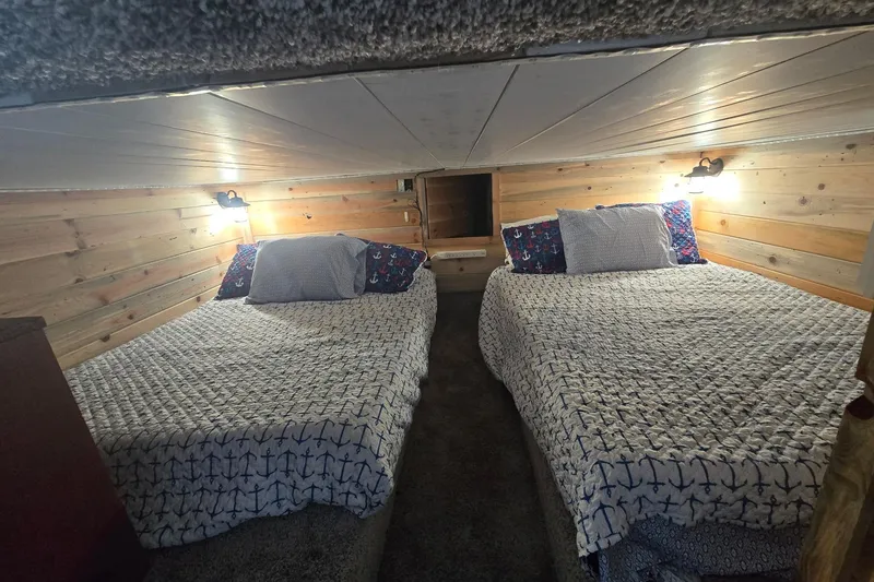 Slide: The Image of Cozy cabin bedroom with twin beds, nautical-themed bedding, and warm wood paneling. - 11