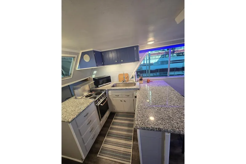 Slide: The Image of 1977 Gibson 50 Standard kitchen with granite countertops and blue cabinets, featuring modern appliances. - 16