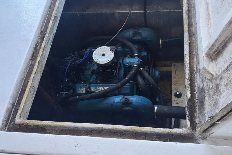Slide: The Image of Engine compartment of a 1977 Gibson 50 Standard boat, featuring a blue marine engine. - 18