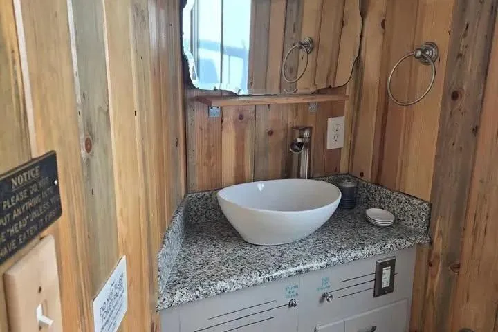 Slide: The Image of Rustic wooden bathroom with vessel sink, granite countertop, and mirror in a 1977 Gibson 50 Standard. - 21