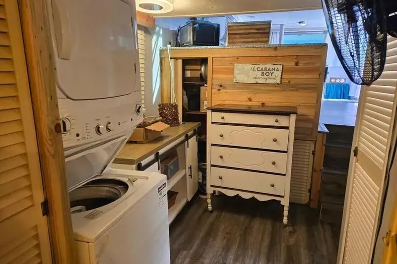 Slide: The Image of Cozy laundry room with stacked washer-dryer, wooden cabinets, and vintage dresser. - 22