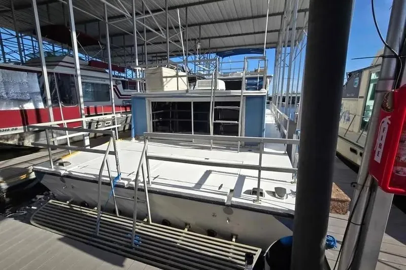 Slide: The Image of 1977 Gibson 50 Standard houseboat docked under a covered marina. - 23