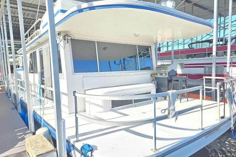 Slide: The Image of 1977 Gibson 50 Standard houseboat docked in a marina, featuring spacious deck and seating area. - 24