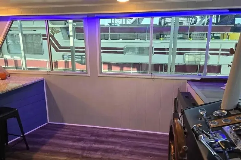 Slide: The Image of Interior of a 1977 Gibson 50 Standard houseboat with large windows and wooden flooring. - 25