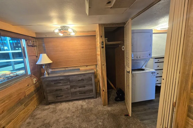 Slide: The Image of Cozy 1977 Gibson 50 Standard interior with wooden walls, dresser, and stacked washer-dryer unit. - 27