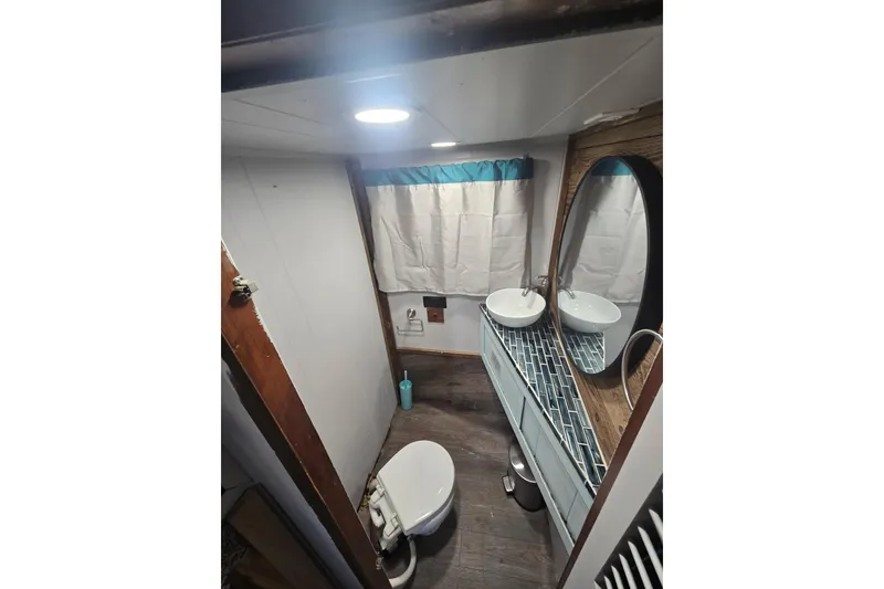 Slide: The Image of Small bathroom in a 1977 Gibson 50 Standard boat with modern fixtures and wood accents. - 30