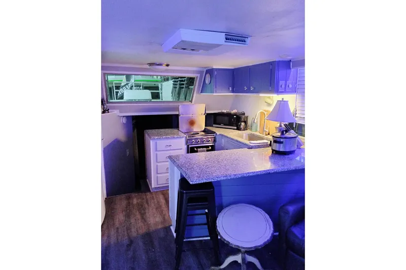 Slide: The Image of 1977 Gibson 50 Standard boat kitchen with modern appliances and blue lighting. - 4