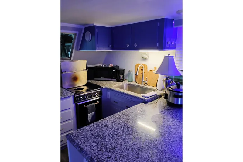 Slide: The Image of Cozy kitchen with granite countertops, blue cabinets, and modern appliances, 1977 Gibson 50 Standard. - 5