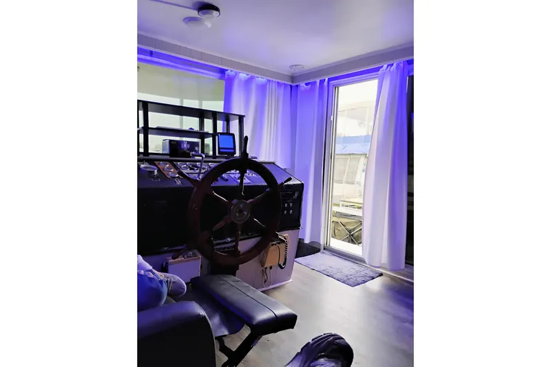 Slide: The Image of Cozy boat interior with steering wheel, blue lighting, and open door, Gibson 50 Standard, 1977. - 6