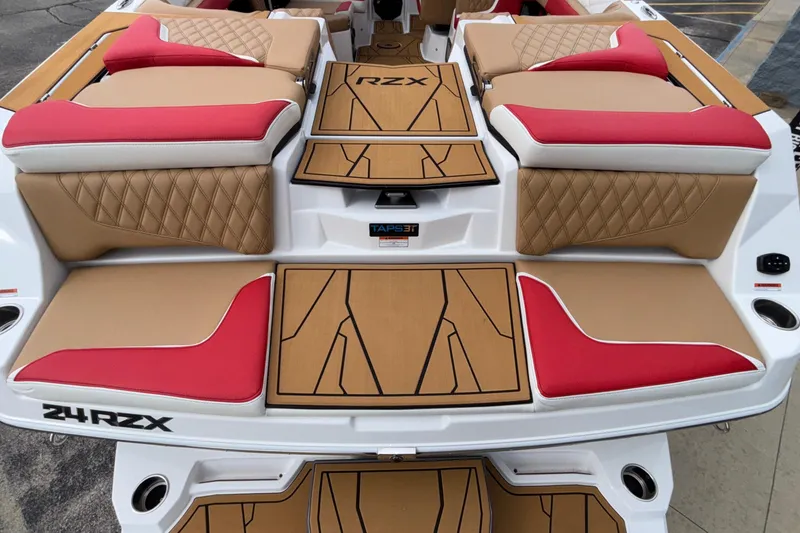 Slide: The Image of 2026 Tigé 24RZX boat interior with red and tan seating, diamond stitching, and teak-style flooring. - 12