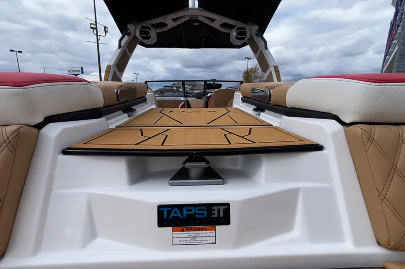 Slide: The Image of 2026 Tigé 24RZX boat interior with TAPS 3T surf system, featuring tan and red seating. - 14