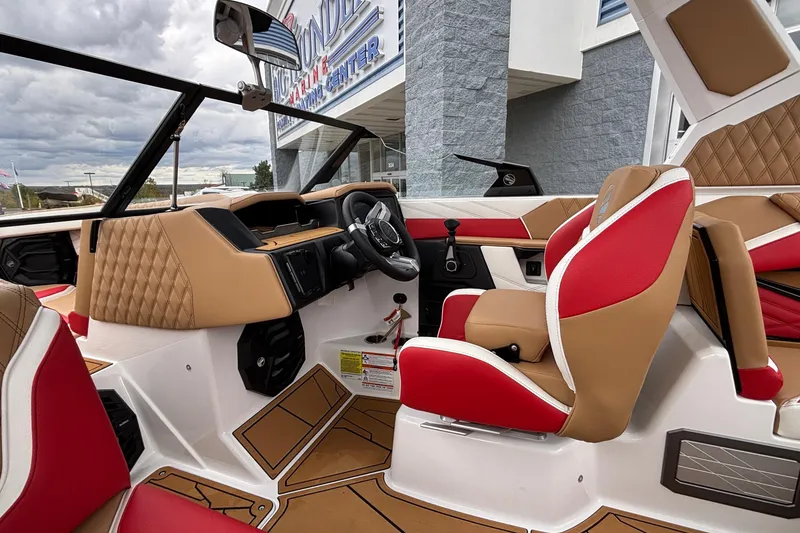 Slide: The Image of 2026 Tigé 24RZX boat interior with red and tan seating, modern dashboard, and steering wheel. - 20