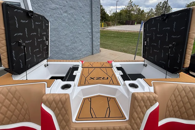 Slide: The Image of 2026 Tigé 24RZX boat interior with open storage compartments and tan seating. - 25