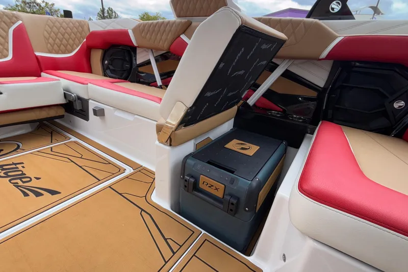 Slide: The Image of 2026 Tigé 24RZX boat interior with red and tan seating, open storage compartment. - 38