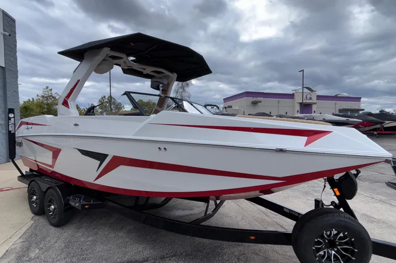 Slide: The Image of 2026 Tigé 24RZX boat with red accents on a trailer, parked outdoors. - 5