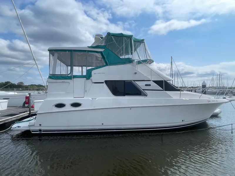 The Image of 2002 Silverton 392 Motor Yacht docked in a marina under a partly cloudy sky. - 1