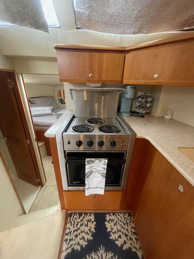 Slide: The Image of 2002 Silverton 392 Motor Yacht kitchen with stove, oven, and wooden cabinetry. - 11