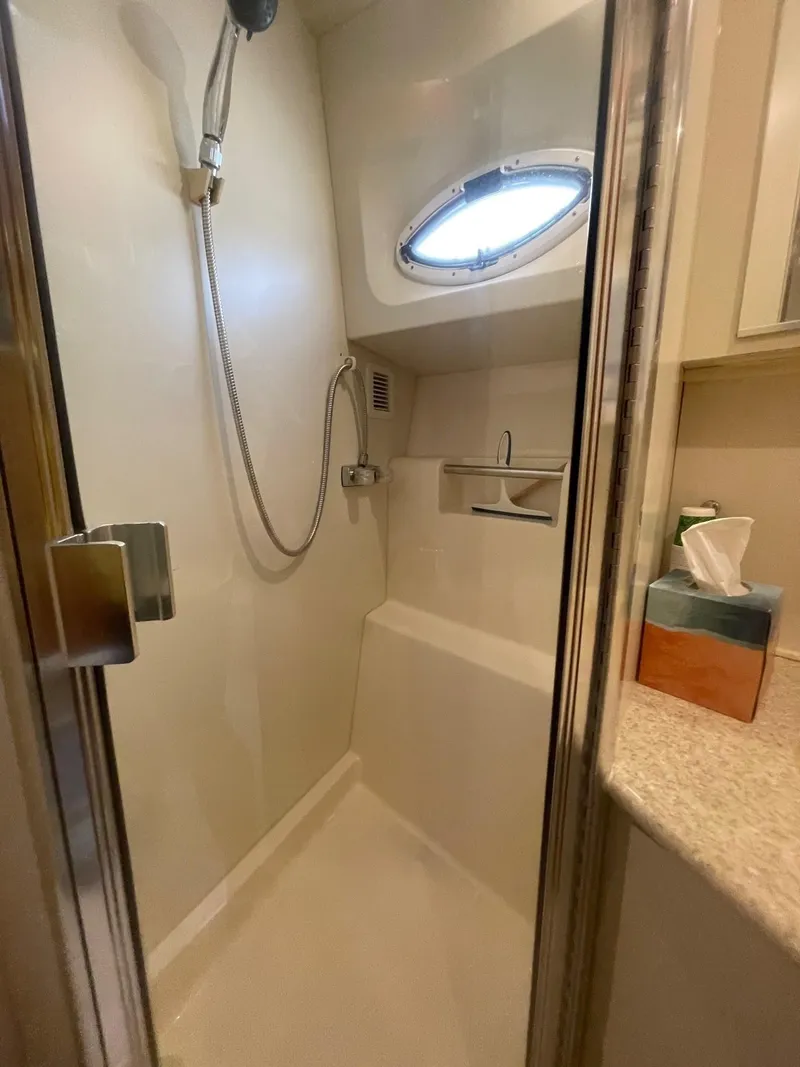 Slide: The Image of Shower area in 2002 Silverton 392 Motor Yacht with modern fixtures and porthole window. - 14