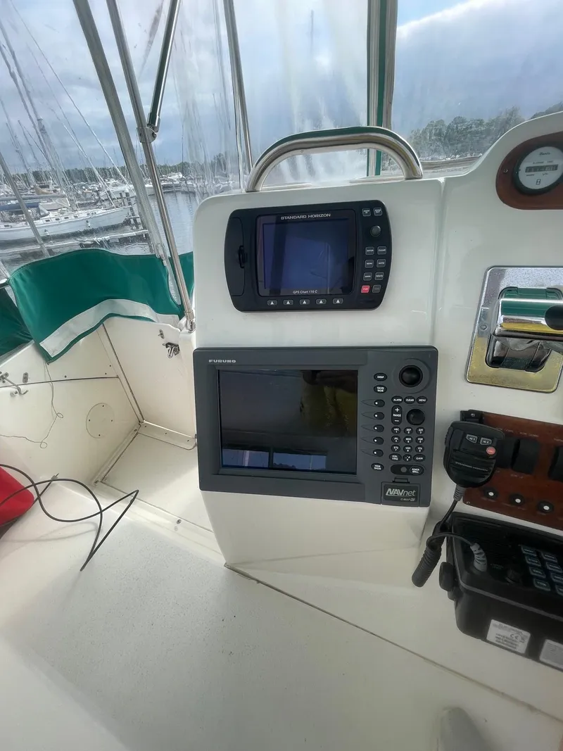 Slide: The Image of 2002 Silverton 392 Motor Yacht helm with navigation equipment and marina view. - 22