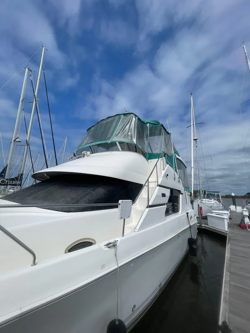 Slide: The Image of 2002 Silverton 392 Motor Yacht docked under a cloudy sky. - 4