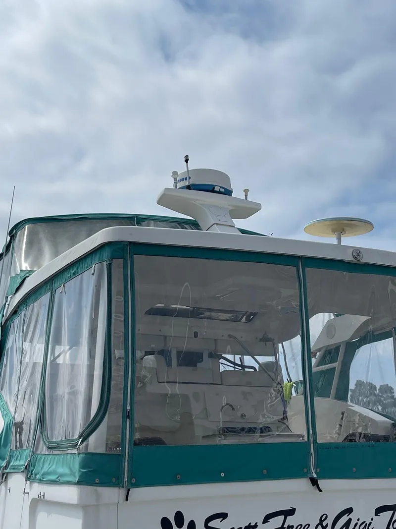 Slide: The Image of 2002 Silverton 392 Motor Yacht with green trim, docked under a cloudy sky. - 5