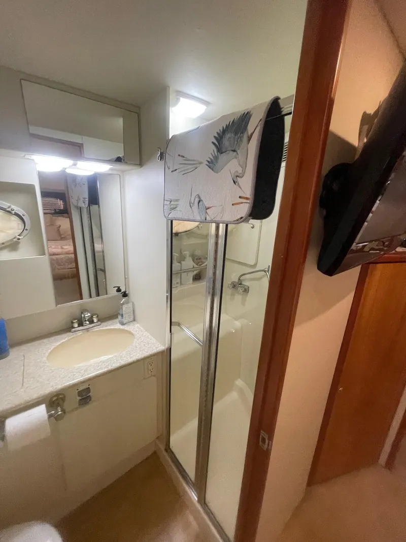 Slide: The Image of 2002 Silverton 392 Motor Yacht bathroom with shower, sink, and mirror. - 6