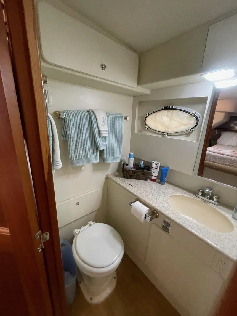Slide: The Image of 2002 Silverton 392 Motor Yacht bathroom with sink, toilet, and towels. - 7