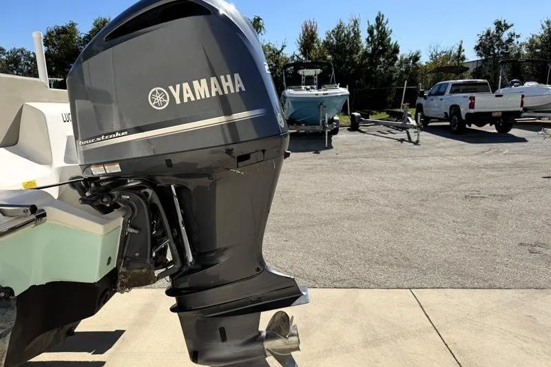Slide: The Image of 2024 Key West 239 FS boat with T-top and rod holders under clear blue sky. - 12