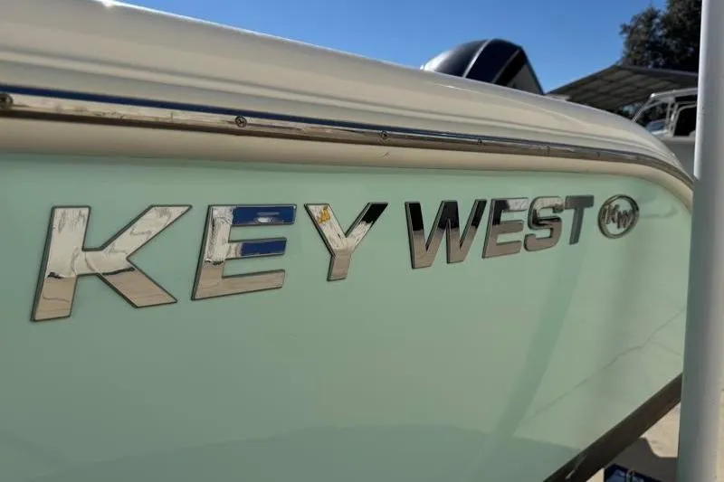 Slide: The Image of 2024 Key West 239 FS boat trailer with contact number, parked in a lot. - 38