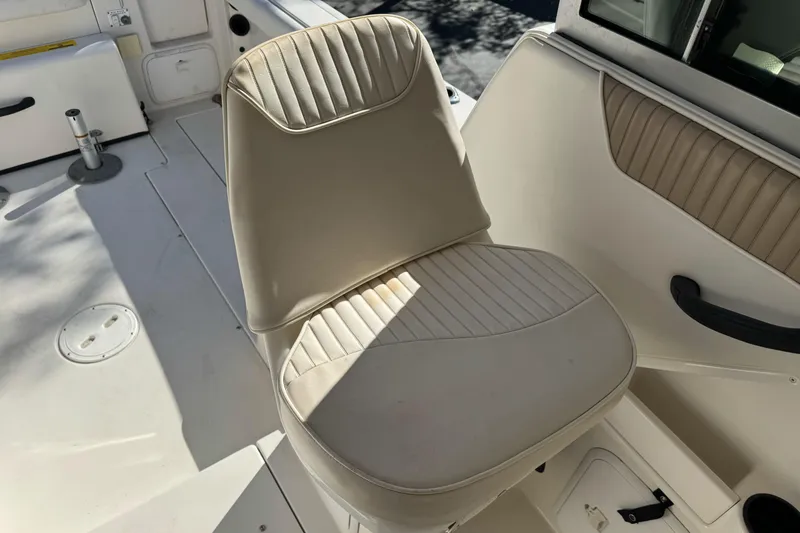 Slide: The Image of 2005 Striper SeaSwirl 2601 boat interior with beige seating and storage compartments. - 13