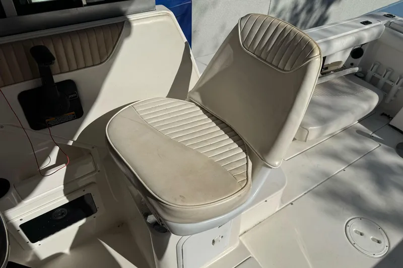 Slide: The Image of 2005 Striper SeaSwirl 2601 boat interior with white cushioned seating. - 14