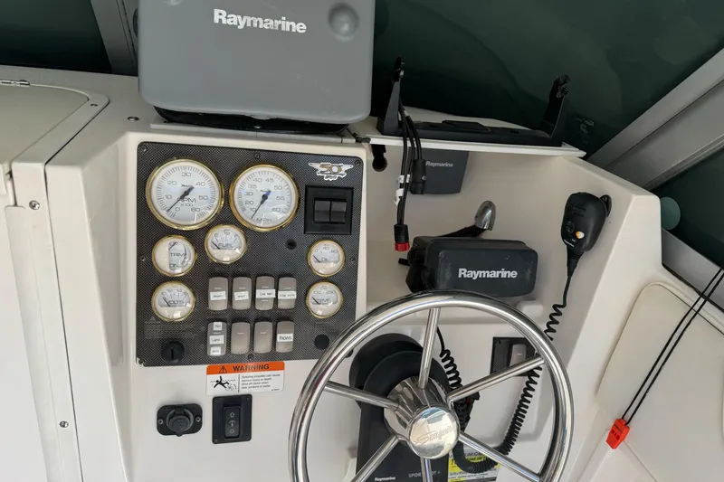 Slide: The Image of 2005 Striper SeaSwirl 2601 boat dashboard with Raymarine equipment and steering wheel. - 15