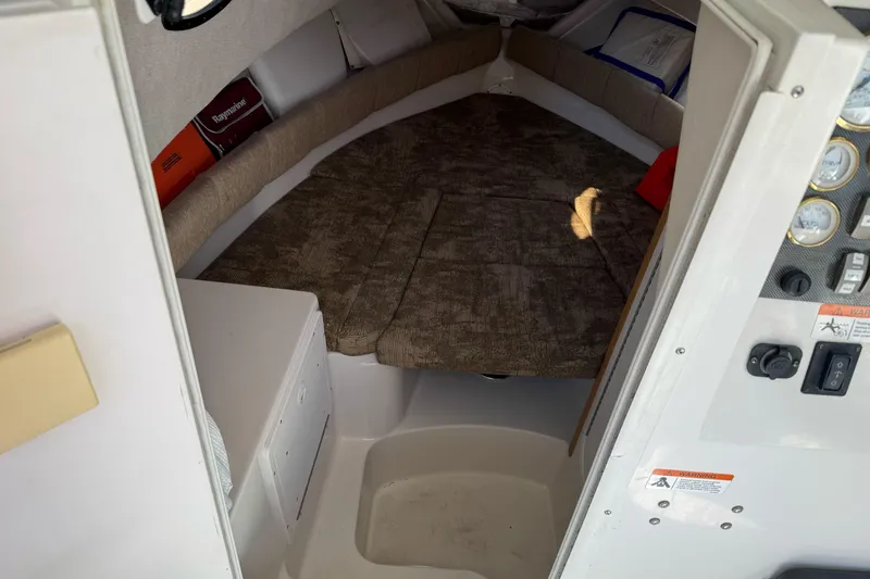 Slide: The Image of 2005 Striper SeaSwirl 2601 cabin interior with cushioned seating and control panel. - 17