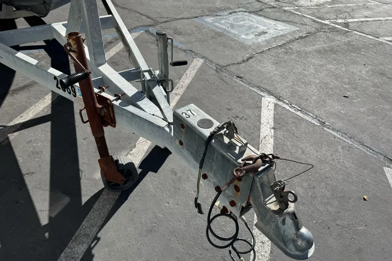 Slide: The Image of Trailer hitch of a 2005 Striper SeaSwirl 2601 boat in a parking lot. - 3