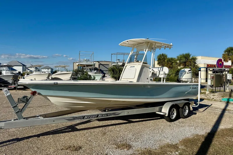 Slide: The Image of 2017 Avenger AV24 boat on trailer in sunny parking lot, palm trees and buildings in background. - 10