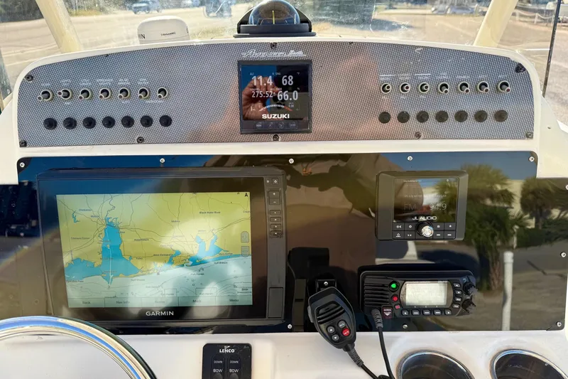 Slide: The Image of 2017 Avenger AV24 boat with center console, parked near a coastal road. - 13