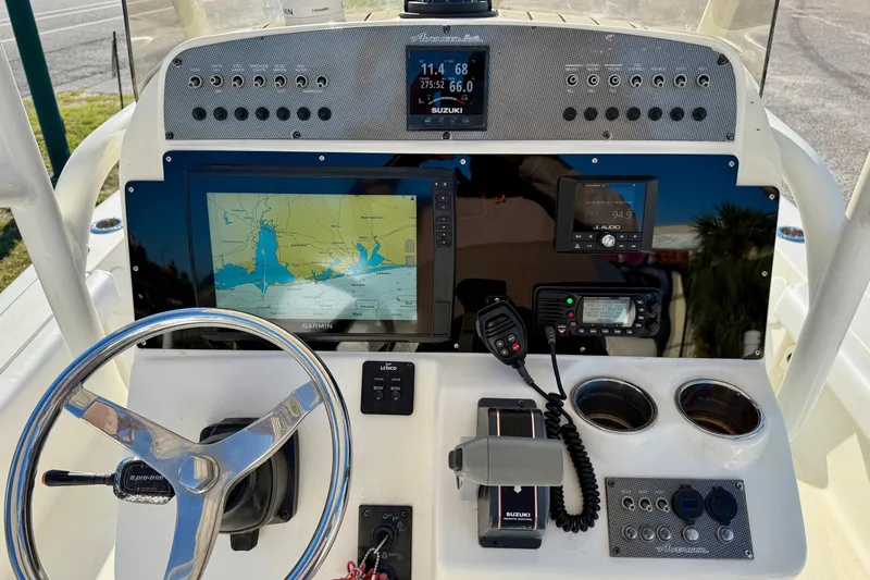 Slide: The Image of Control panel of a 2017 Avenger AV24 boat with navigation equipment and steering wheel. - 17