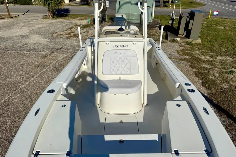 Slide: The Image of 2017 Avenger AV24 boat interior with seating and storage compartments, parked near a road. - 18