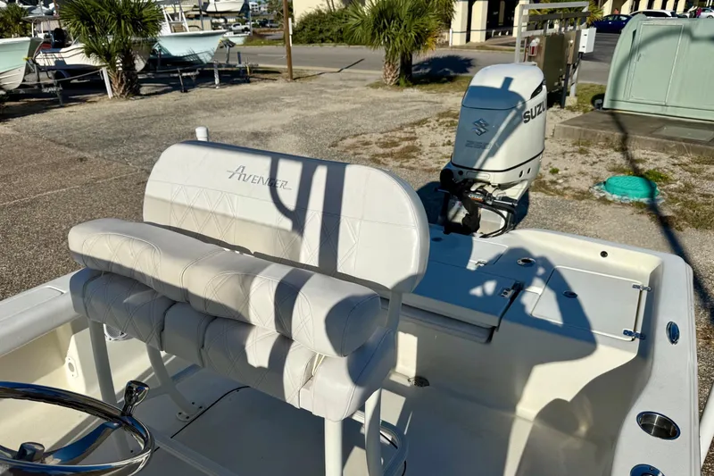 Slide: The Image of 2017 Avenger AV24 boat parked near marina with palm trees and buildings in background. - 20