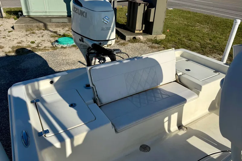 Slide: The Image of 2017 Avenger AV24 boat on trailer, parked near a road with palm trees. - 24