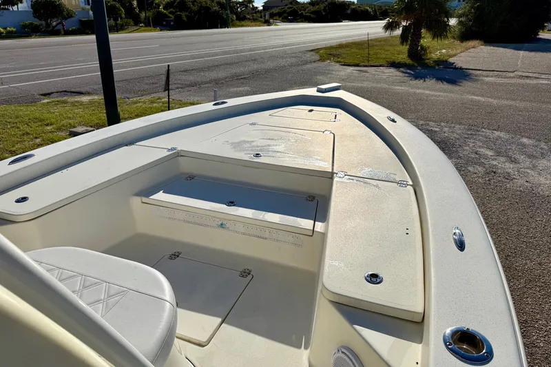 Slide: The Image of 2017 Avenger AV24 boat on trailer with Suzuki outboard motor, parked near buildings. - 25