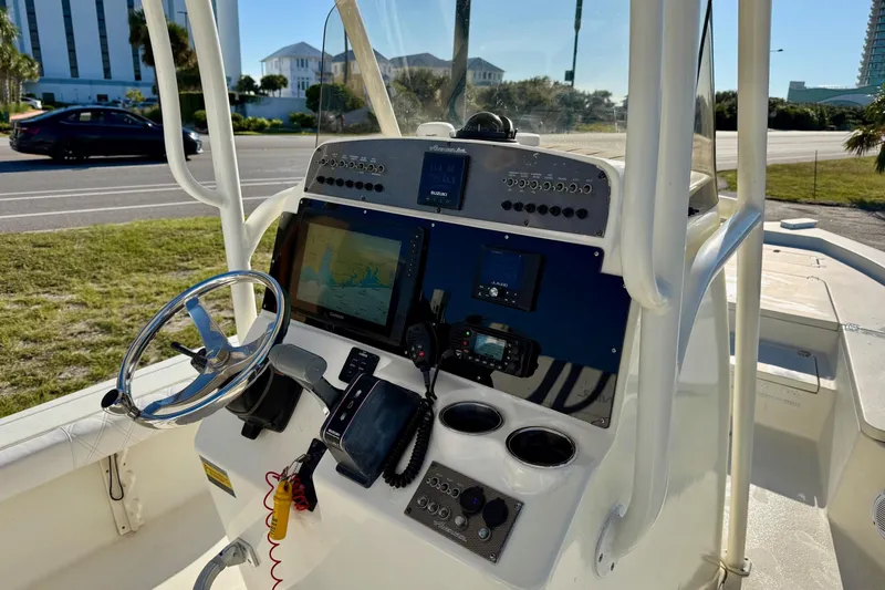 Slide: The Image of 2017 Avenger AV24 boat on trailer with Suzuki outboard motor, parked near road. - 26