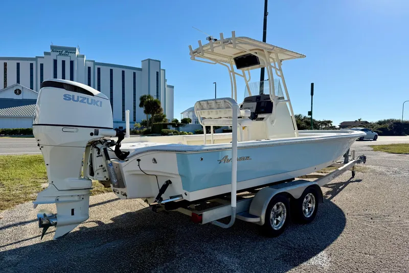 Slide: The Image of 2017 Avenger AV24 boat on trailer, urban backdrop, clear sky. - 4