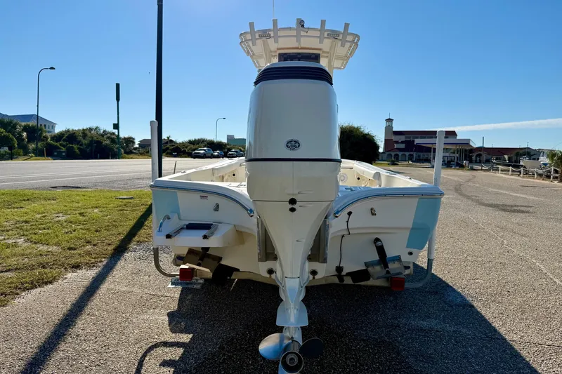 Slide: The Image of 2017 Avenger AV24 boat on trailer with Suzuki outboard motor, parked near buildings. - 5