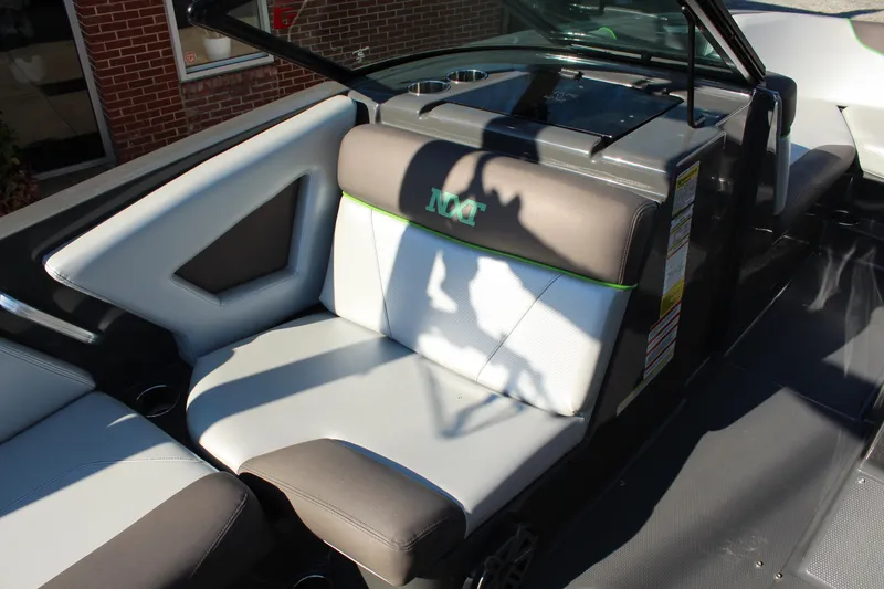 Slide: The Image of 2017 MasterCraft NXT22 boat interior with gray and white seating, cup holders, and sleek design. - 11