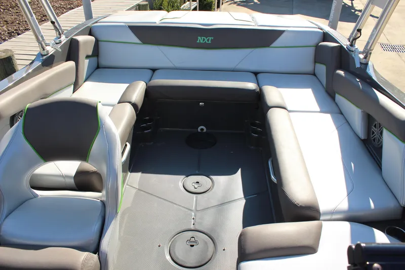 Slide: The Image of 2017 MasterCraft NXT22 boat interior with gray and white seating, green accents. - 17