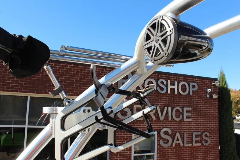 Slide: The Image of 2017 MasterCraft NXT22 boat tower with speakers and board racks, against a brick building. - 18