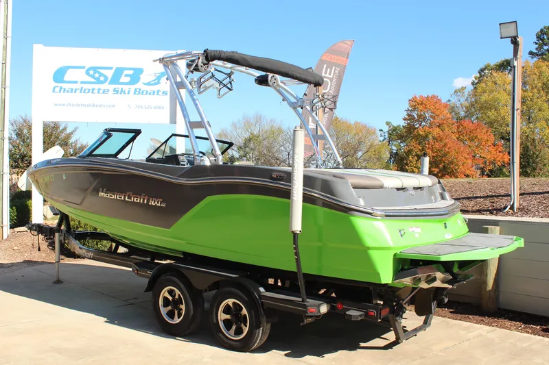 Slide: The Image of 2017 MasterCraft NXT22 boat in vibrant green on trailer at Charlotte Ski Boats dealership. - 3