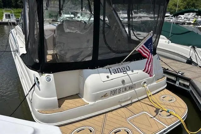 Slide: The Image of 2001 Sea Ray 340 Sundancer docked, displaying American flag and "Tango" name. - 12